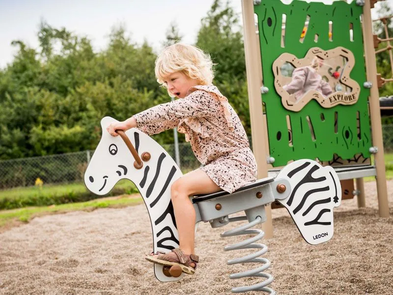 Federwipptier Zebra mit wippendem Kind Federwipptier Zebra mit wippendem Kind